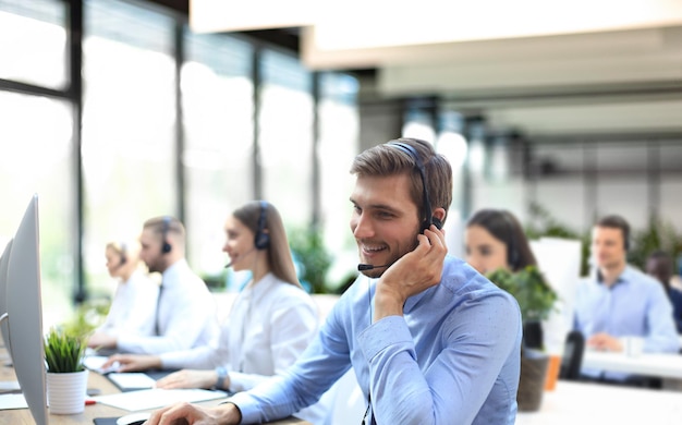 Portret van een callcenterwerker vergezeld van zijn team Glimlachende klantenserviceoperator aan het werk