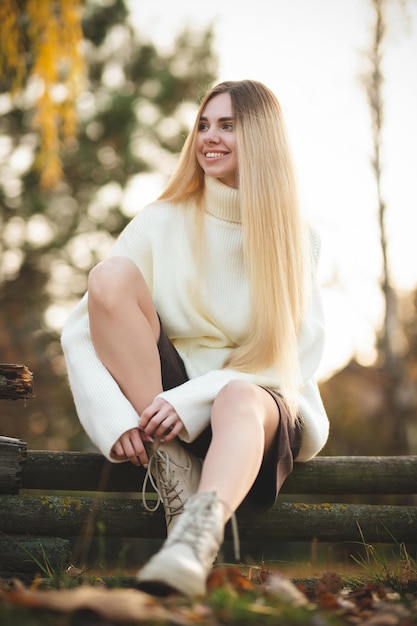 Portret van een charmante blondine met een prachtige glimlach Meisje in een witte trui