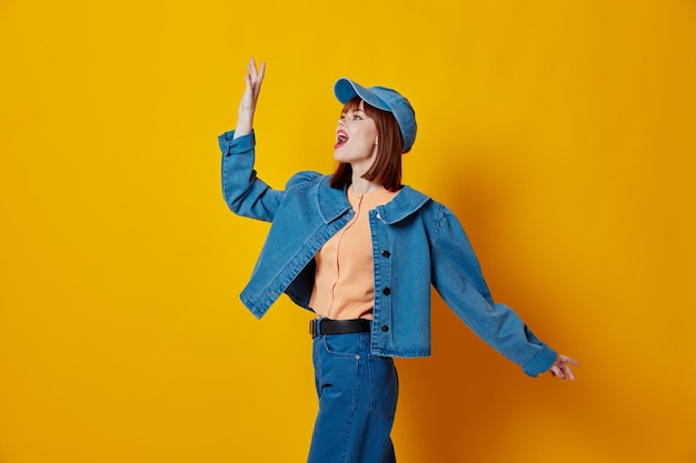 Portret van een charmante dame denim pet rode lippen glamour mode gele achtergrond ongewijzigd