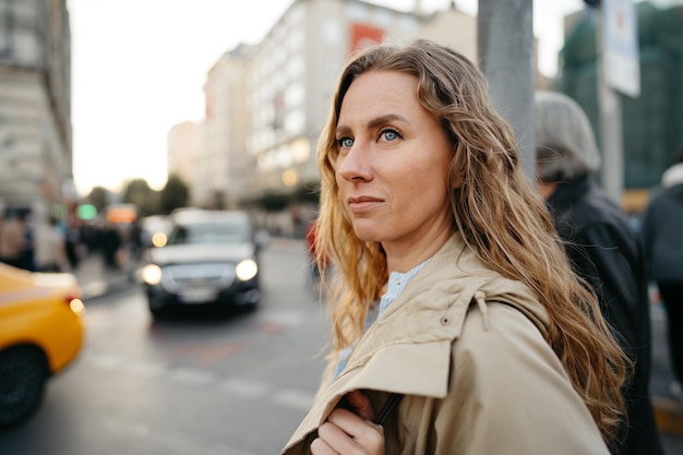 Portret van een charmante jonge vrouw die poseert voor de camera in de stad