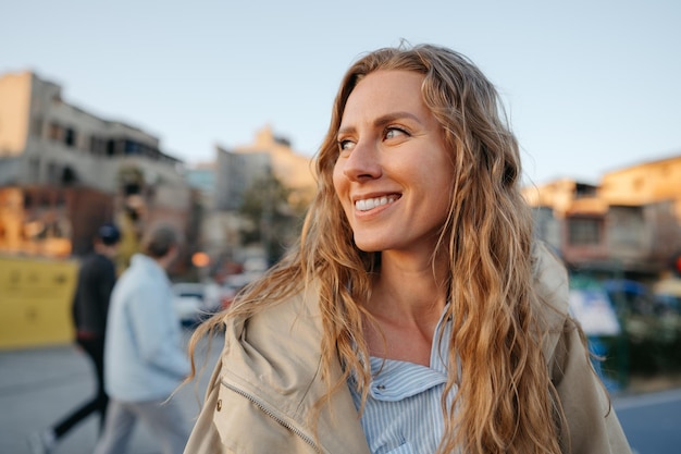 Portret van een charmante jonge vrouw die poseert voor de camera in de stad