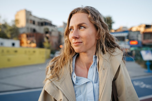 Portret van een charmante jonge vrouw die poseert voor de camera in de stad