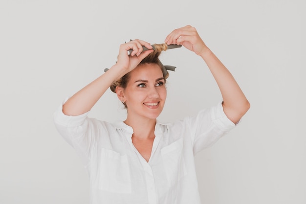 Portret van een charmante jonge vrouw in krulspelden.