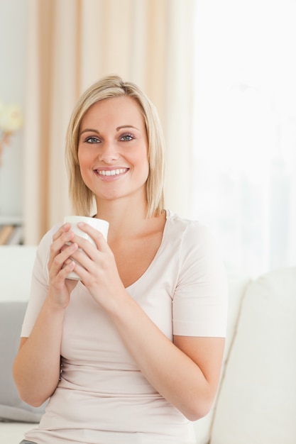 Portret van een charmante vrouw die een kopje koffie