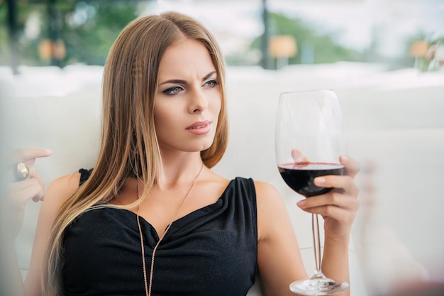 Portret van een charmante vrouw rode wijn drinken in restaurant