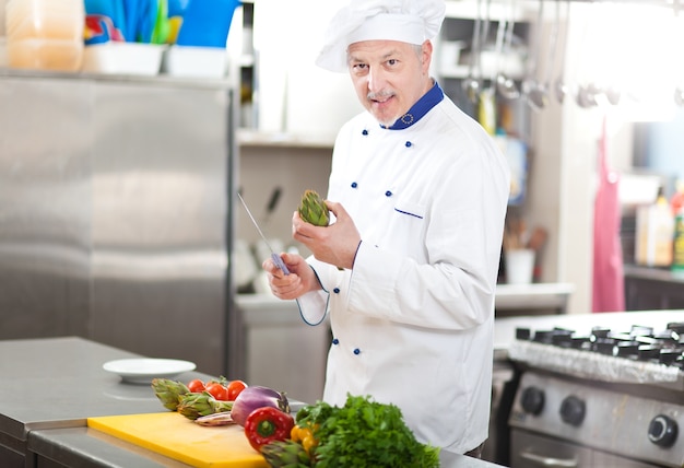 Portret van een chef-kok aan het werk in zijn keuken