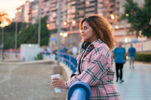 Portret van een curvy curlyhaired vrouw peinzend bij zonsondergang