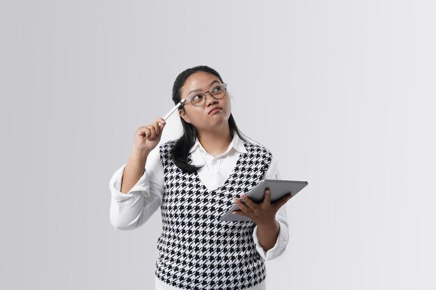 Portret van een doordachte aziatische vrouw zette een potlood op haar hoofd, een serieuze gezichtsuitdrukking in casual