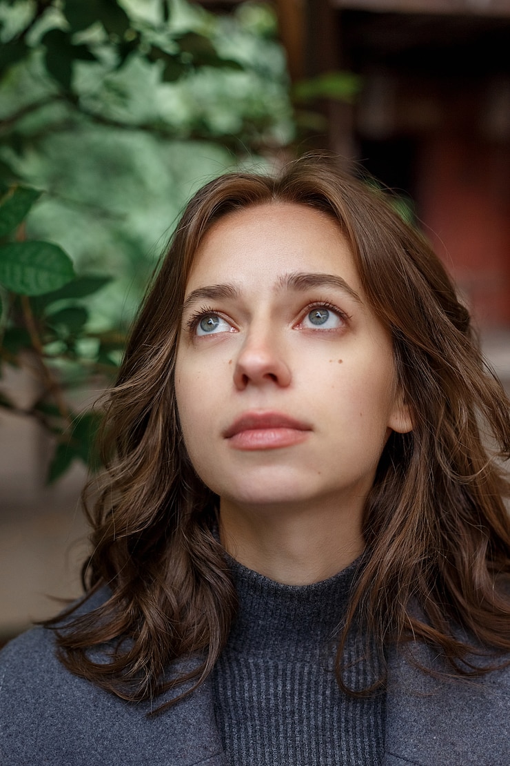 Foto portret van een doordachte meisje in grijze jas en coltrui poseren buitenshuis