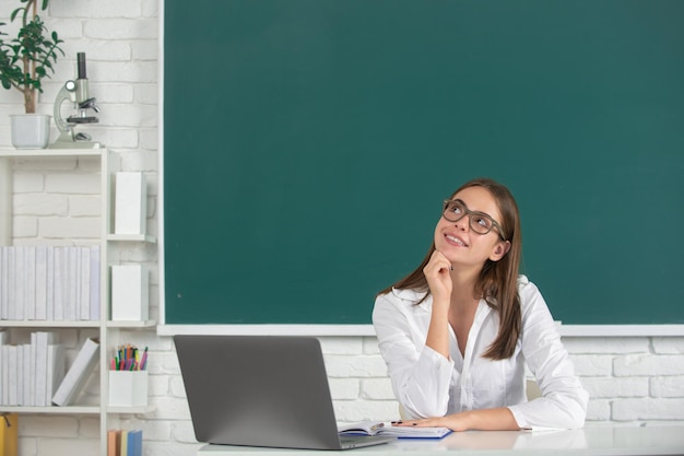 Portret van een dromende jonge student in de klas op schoolbord achtergrond kopie ruimte