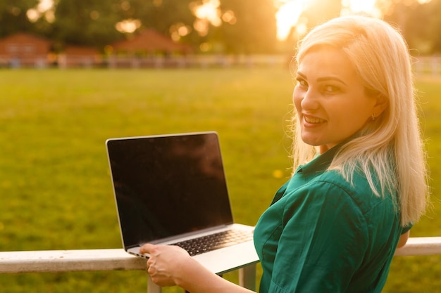 Portret van een drukke verkoopvrouw die op een bedrijventerrein zit en haar laptop gebruikt. Zakenvrouw die online werkt.