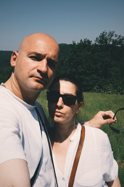 Foto portret van een echtpaar tegen bomen en hemel