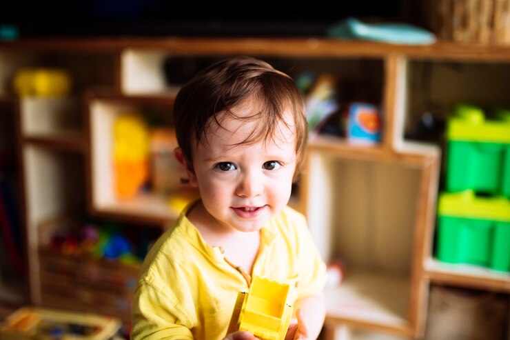 Portret van een éénjarige baby die thuis met speelgoed speelt