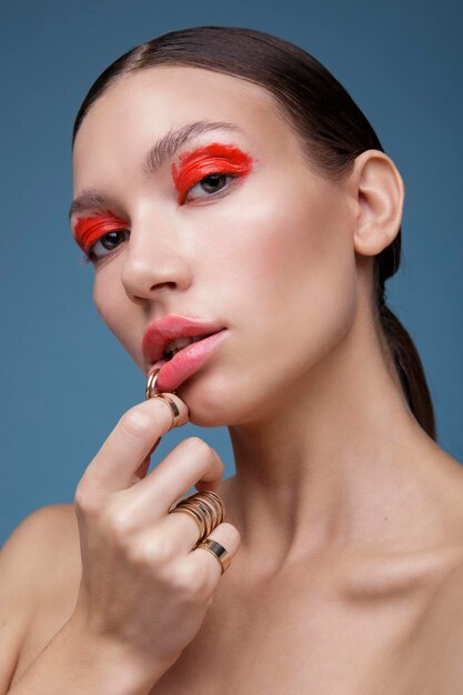 Portret van een elegante jonge vrouw met rode lichte make-up op een blauwe achtergrond. Schoonheid mode