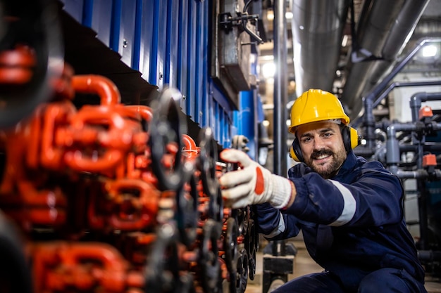 Portret van een fabrieksarbeider die de waterdruk regelt in een verwarmingsinstallatie