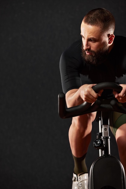 Portret van een fietser met een baard op een donkere achtergrond