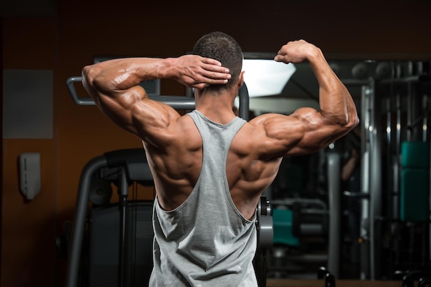 Portret van een fysiek fitte jonge man die zijn spieren buigt