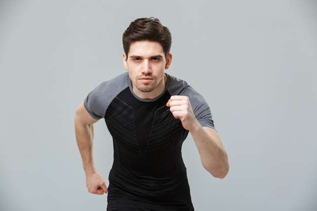 Portret van een geconcentreerde jonge sportman klaar om te rennen