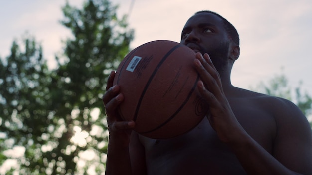Portret van een gefocuste Afrikaanse streetballspeler die alleen basketbal beoefent