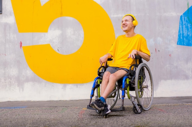 Portret van een gehandicapte in het geel gekleed in een rolstoel die naar muziek luistert