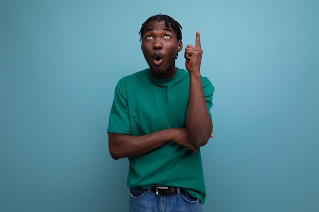 Portret van een gelikte Afrikaanse jonge kerel in een t-shirt op een blauwe achtergrond