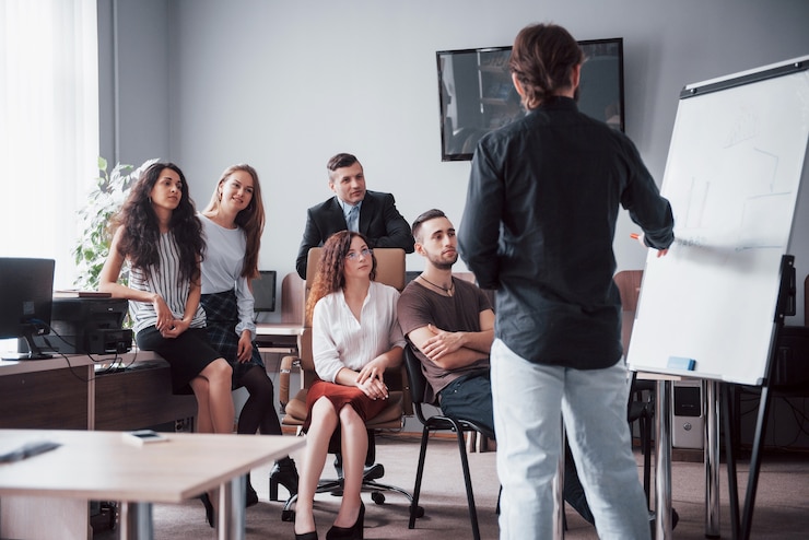 Foto portret van een gelukkig creatief team van mensen praten in het kantoor tijdens de vergadering.