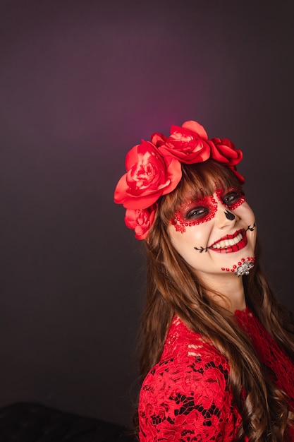 Portret van een gelukkig jong meisje met Dia de los Muertos make-up met kopieerruimte.