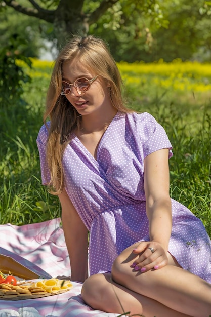 Portret van een gelukkig jong meisje met een picknick in het park Rust buiten de stad