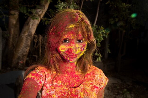 Portret van een gelukkig jong meisje op het festival van kleuren Holi. Meisje poseren en vieren het festival van kleuren.