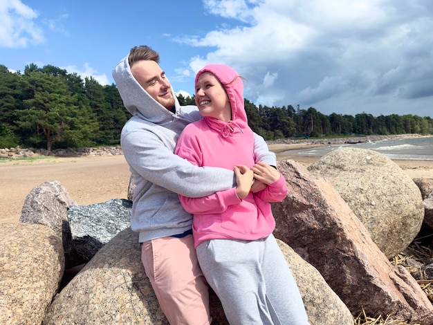 Portret van een gelukkig jong stel dat op het strand loopt, knuffelt elkaar graag en ontspant