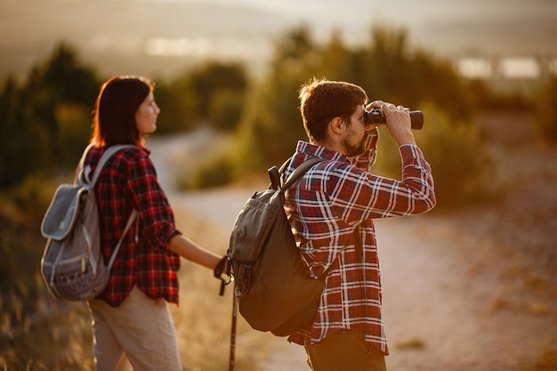 Portret van een gelukkig jong stel dat plezier heeft tijdens hun wandeltocht kaukasisch en aziatisch wandelpaar dat geniet van de zomervakantie