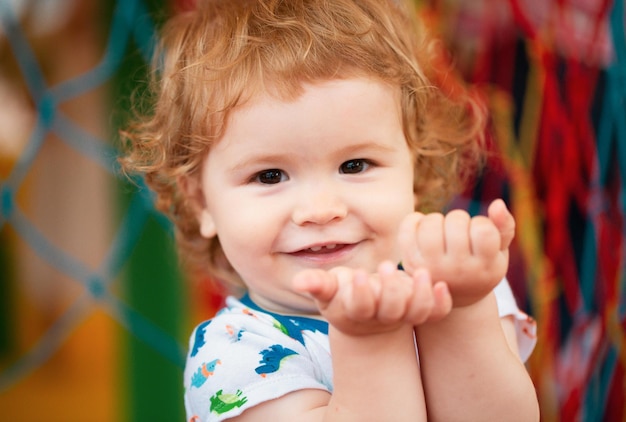 Portret van een gelukkig lachend babykind op speelplaats Close-up positief kindergezicht