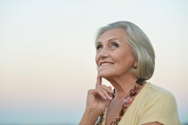 Portret van een gelukkig lachende senior vrouw buitenshuis