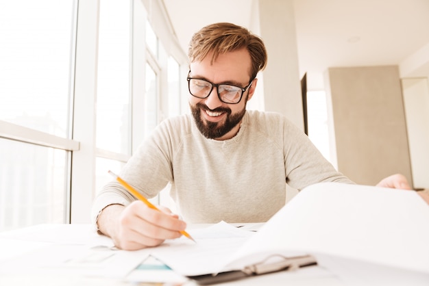 Portret van een gelukkig man aan het werk met documenten