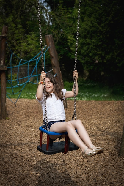 Foto portret van een gelukkig meisje dat op een schommel rijdt