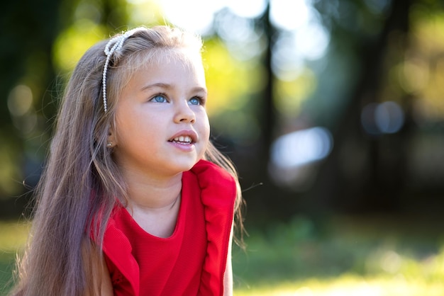 Portret van een gelukkig mooi kindmeisje dat buiten lacht en geniet van een warme zonnige zomerdag.