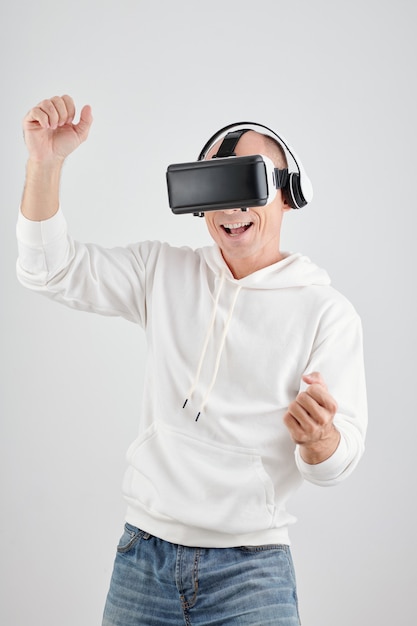 Portret van een gelukkig opgewonden volwassen man die geniet van het spelen van videogames in een virtual reality-headset