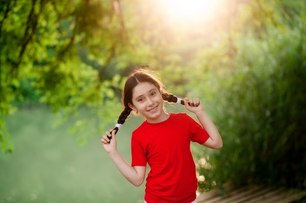 Portret van een gelukkig schattig meisje in de natuur op een zomeravond