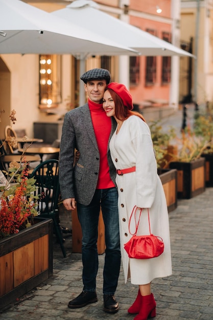 Portret van een gelukkig stel dat op straat loopt in een herfststad Stijlvol stel in retrostijl in de herfst in de stad