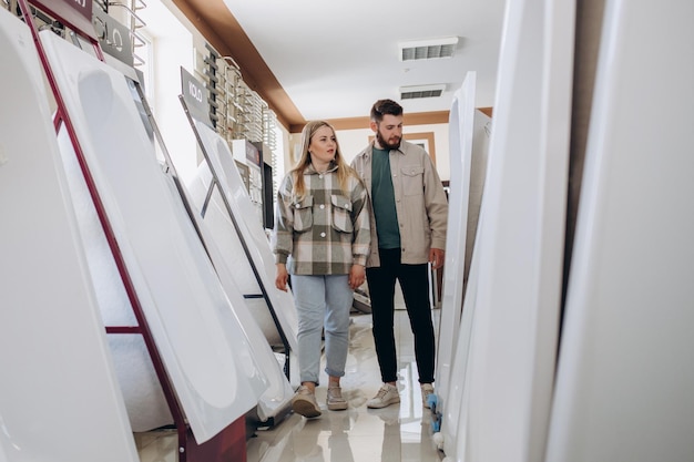 Portret van een gelukkig stel in de buurt van een nieuw bad in de moderne winkel