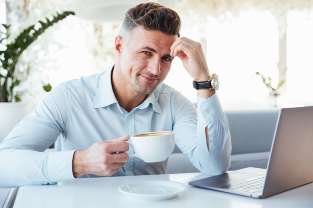 Portret van een gelukkig volwassen man met laptopcomputer