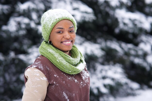 Portret van een gelukkige afro-amerikaanse jonge vrouw op een besneeuwde winterdag in de glimlach van het snowpark