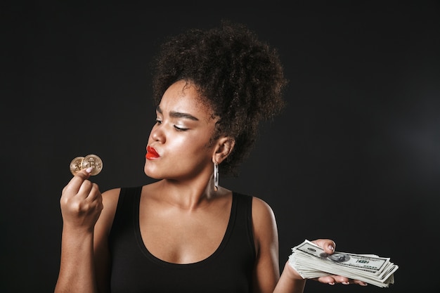 Portret van een gelukkige Afro-Amerikaanse vrouw die make-up draagt ?? die zich geïsoleerd over zwarte ruimte bevindt