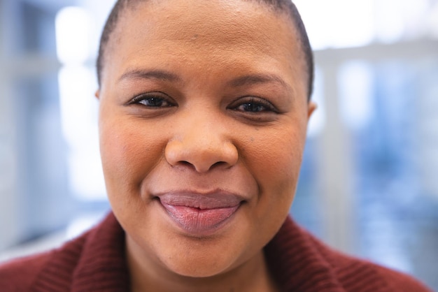 Portret van een gelukkige Afro-Amerikaanse vrouwelijke patiënt in de wachtkamer van een ziekenhuis. Ziekenhuis, medicijnen en gezondheidszorg, onveranderd.