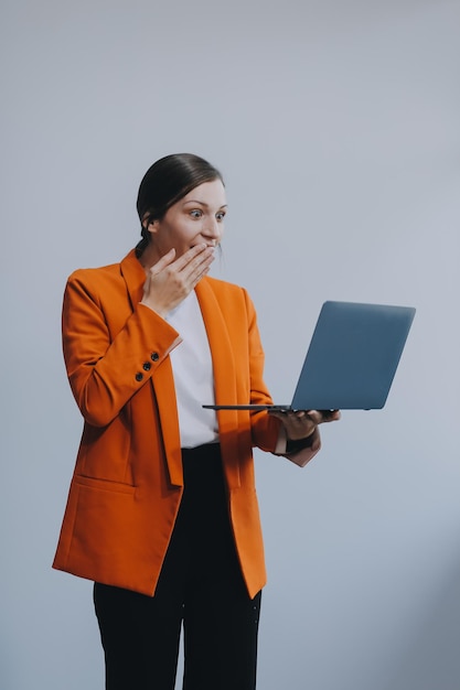 Portret van een gelukkige Aziatische zakenvrouw die aan een laptop werkt, geïsoleerd op een witte achtergrond