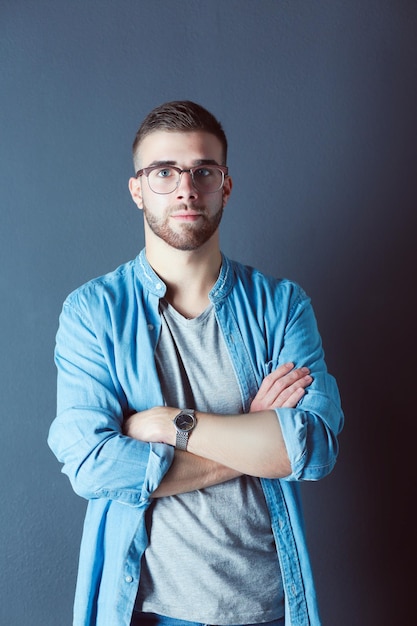 Portret van een gelukkige casual man die geïsoleerd op een donkere achtergrond staat