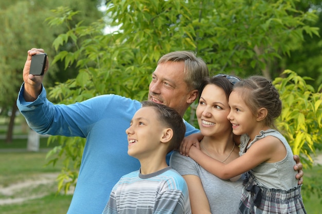 Portret van een gelukkige familie die selfie neemt in het park