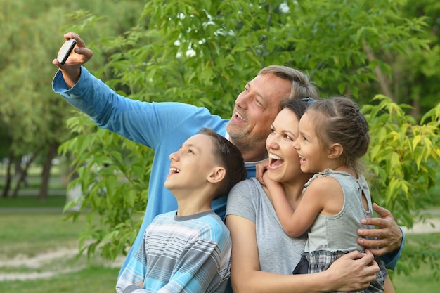 Portret van een gelukkige familie die selfie neemt in het park