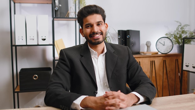 Portret van een gelukkige glimlachende baarde Indiase zakenman thuis kantoor kijk weg draai je hoofd naar de camera