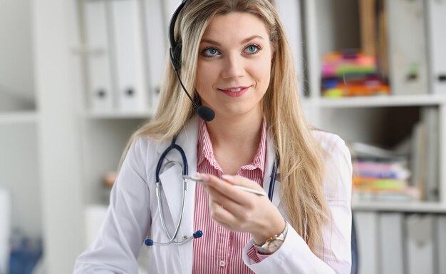 Portret van een gelukkige glimlachende jonge dokter in een headset